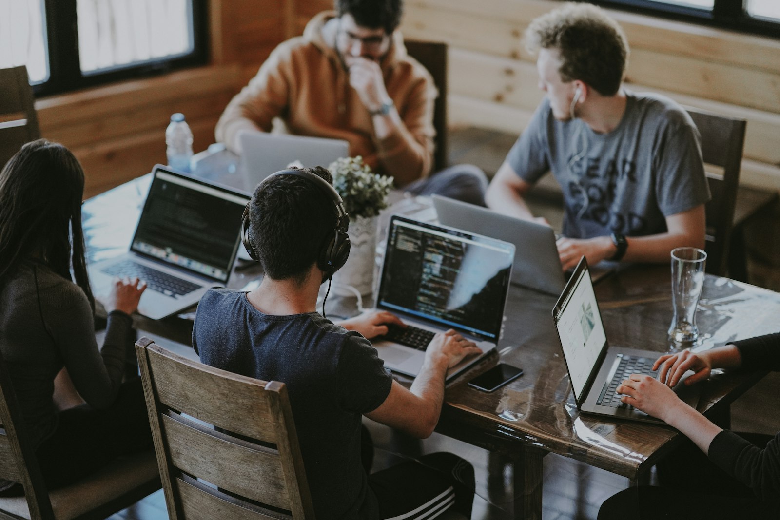 A team collaborating around laptops at a shared table